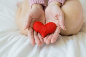 holding a red heart in palm of hands